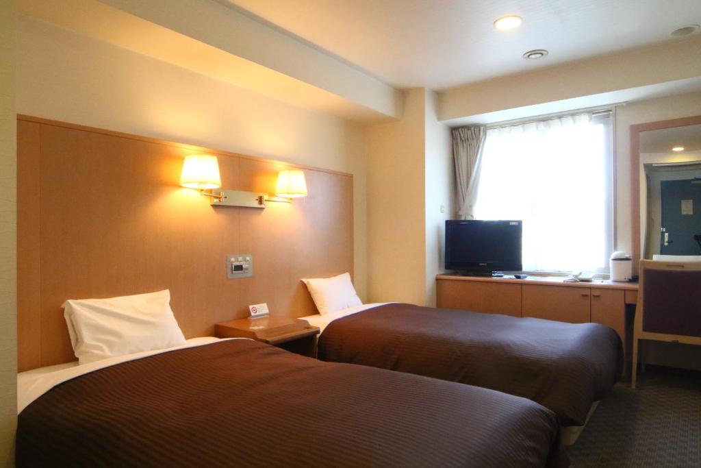 Una cama o camas en una habitación de Sapporo Classe Hotel