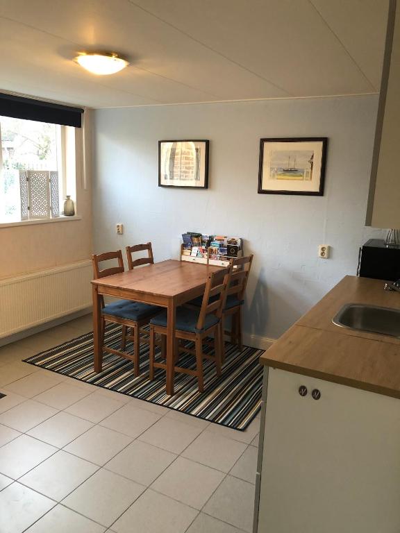a kitchen with a wooden table and chairs and a sink at B&B Kleine Vliet in Medemblik