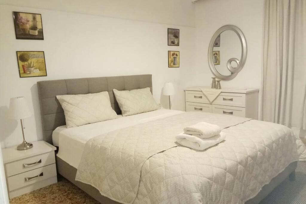 a white bedroom with a bed with towels on it at CENTRAL TOWN HOUSE 60m2**** in Piraeus