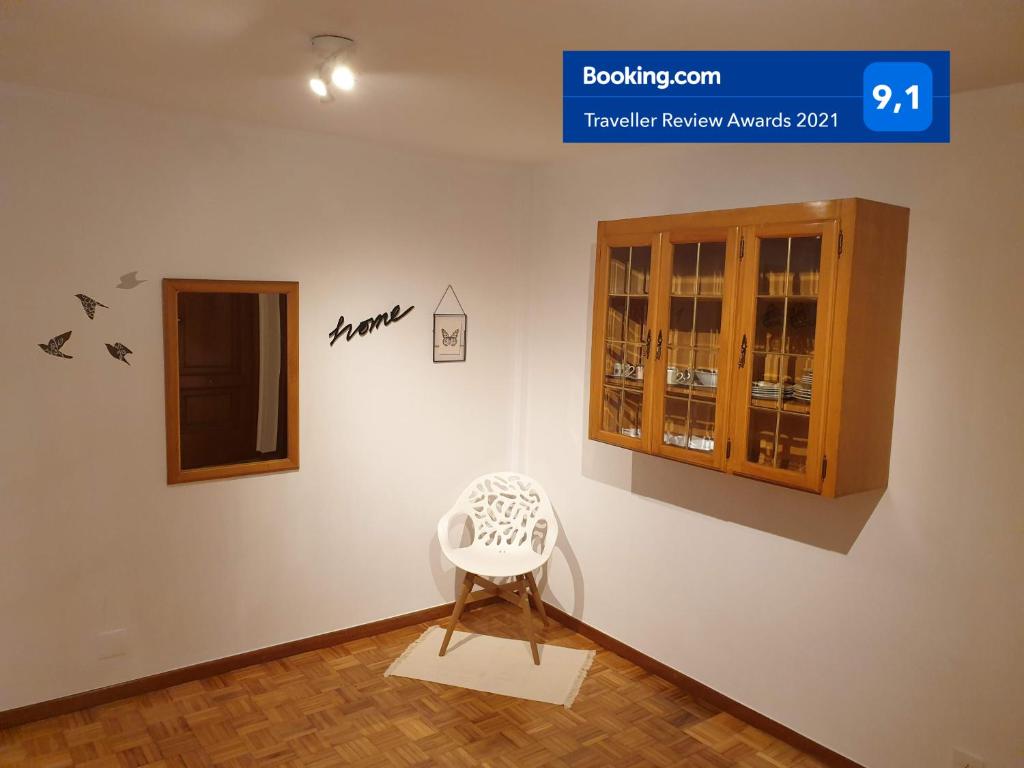 a white chair sitting next to a wall with a cabinet at Céntrico, amplio y bonito apartamento en Cambados in Cambados