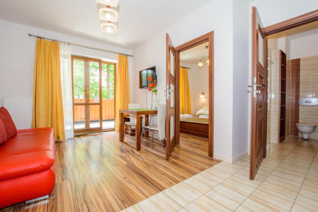 WILLA ORNAK في زاكوباني: غرفة معيشة مع أريكة حمراء وطاولة