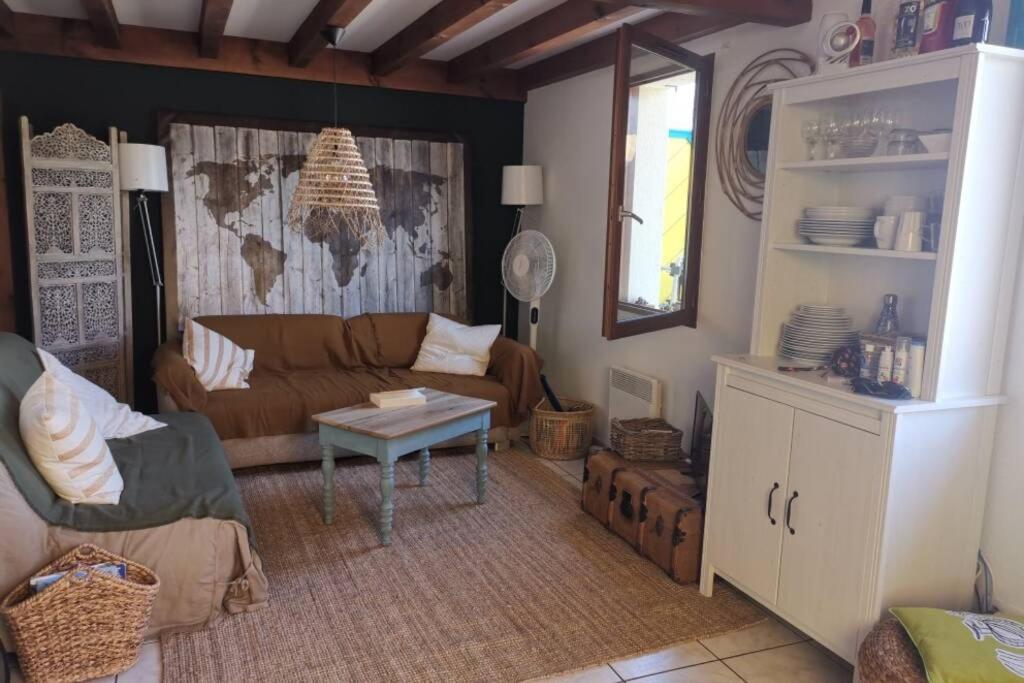 a living room with a couch and a table at Maison au coeur des Landes, Saint-Julien en Born in Saint-Julien-en-Born