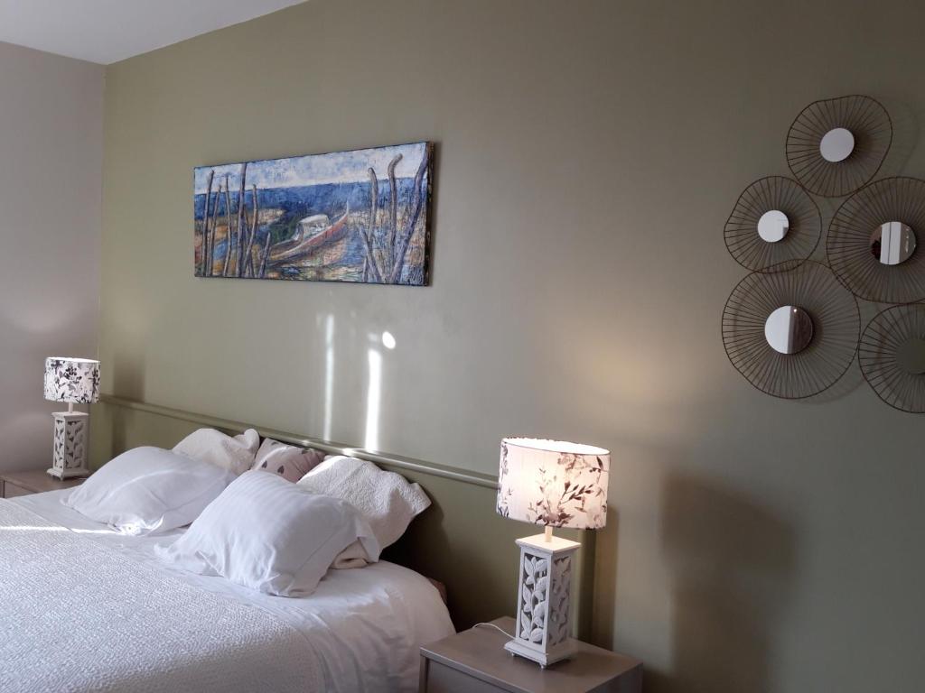 1 dormitorio con 1 cama y una pintura en la pared en Chambre d'Hôtes de L'Abricotier, en Saint-Macaire