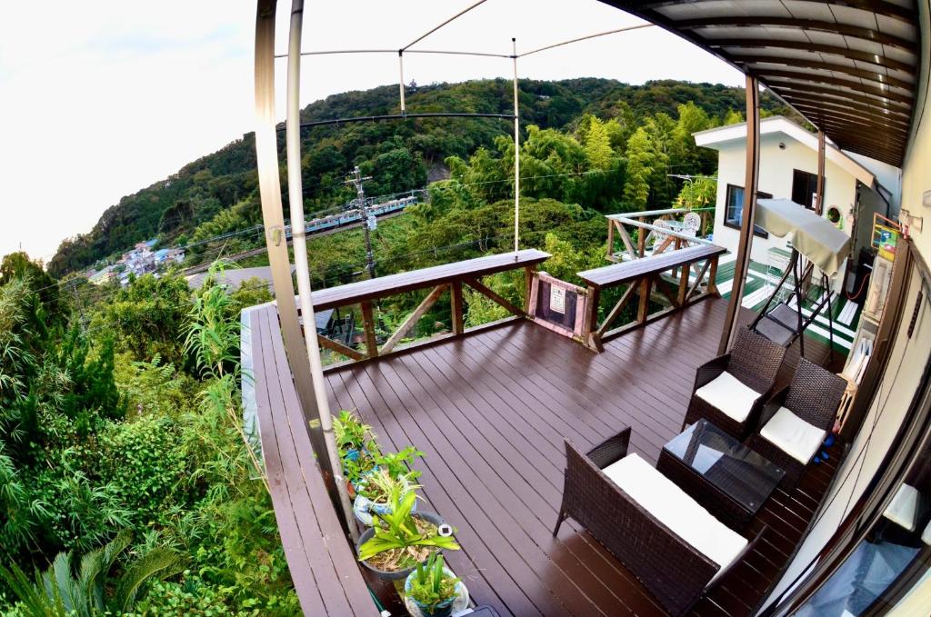 a balcony of a house with a deck with benches at Breathtaking View House in Ito