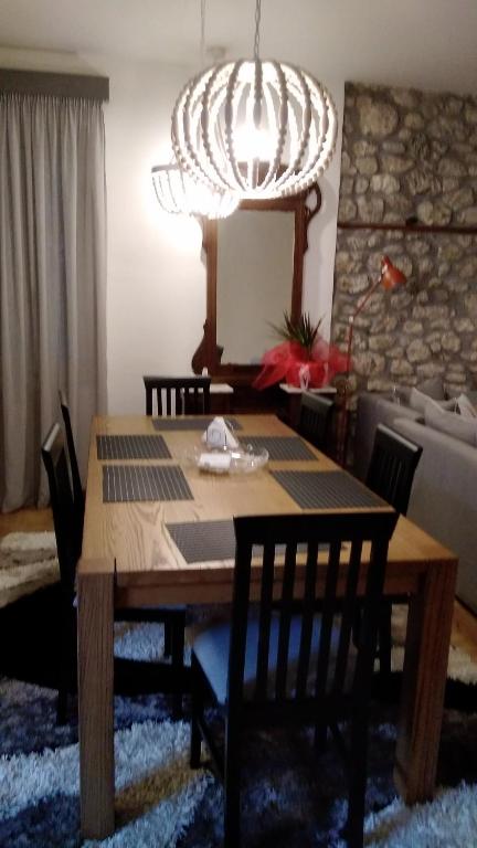 tavolo da pranzo con sedie e lampadario pendente di CRECIAN WATER FRONT a Egira
