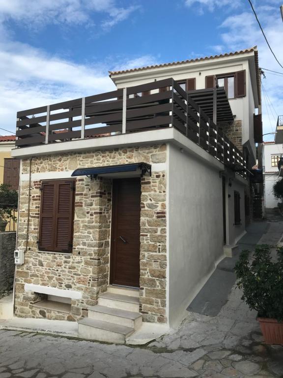 een klein huis met een balkon erboven bij SAMOS MARIAs' STONE HOUSE 1 in Karlovasi