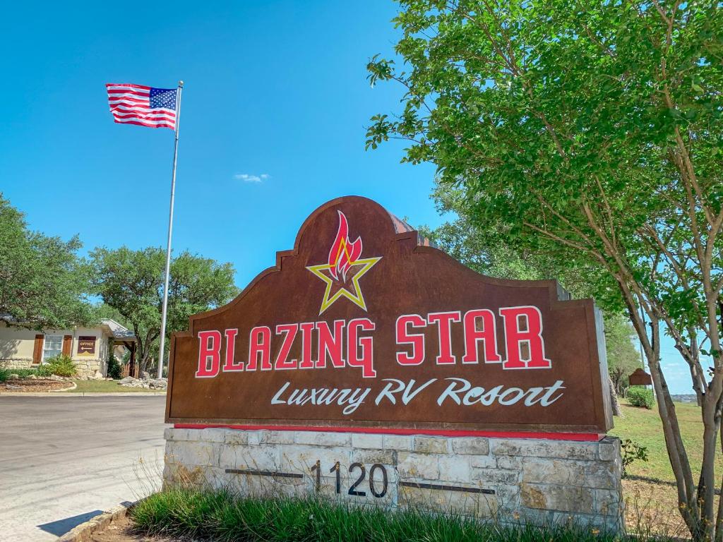a sign for a blazing star luxury rv resort with an american flag at Sun Retreats San Antonio West in San Antonio