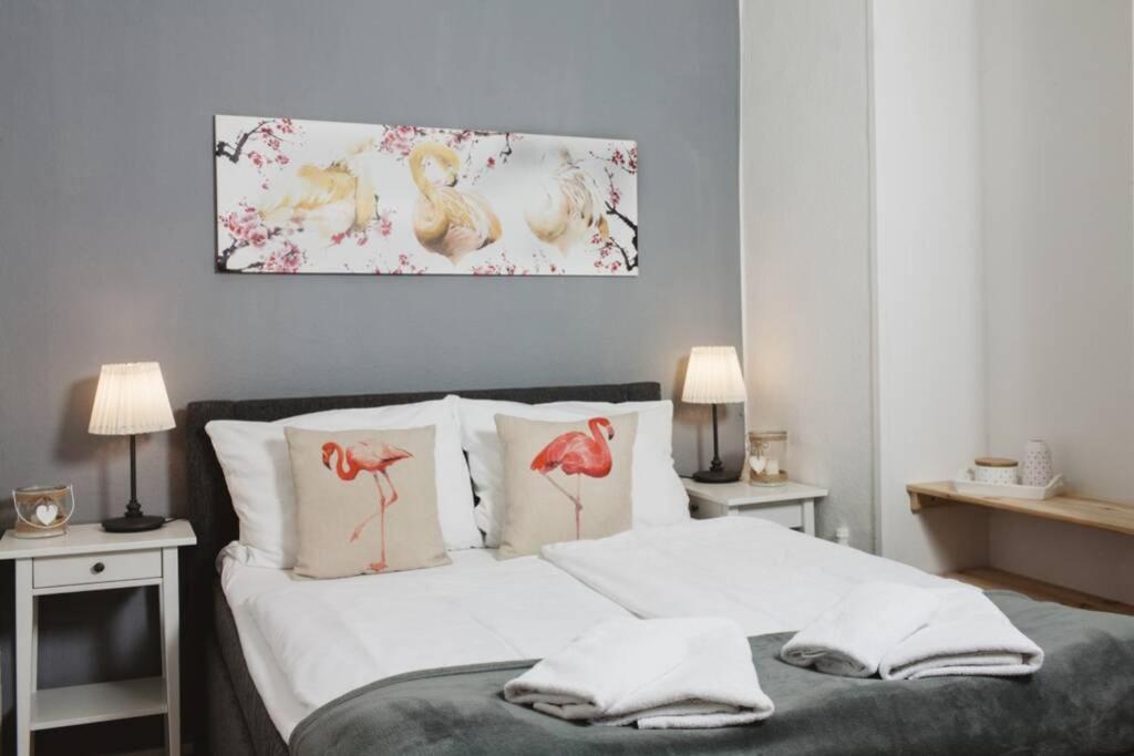 Un dormitorio con una cama con almohadas y pájaros. en City Apartment near Shooping Center, 6 guests, en Berlín