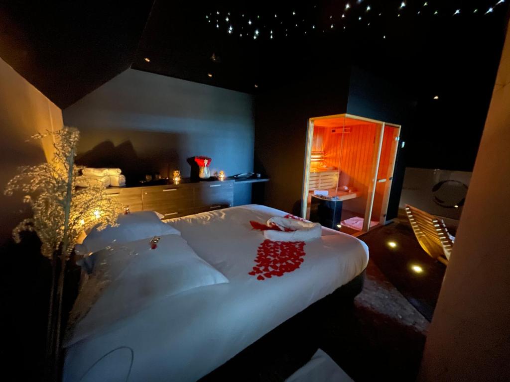 Un dormitorio con una cama grande con corazones rojos. en Octavie - Suite de luxe à Tournai avec piscine privée, jacuzzi, sauna et hammam en Tournai