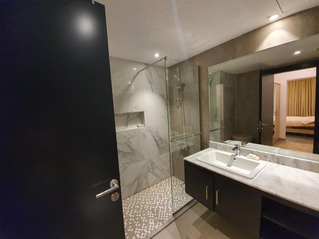 y baño con lavabo y ducha acristalada. en villa in king Abdullah economic city luxury feel W private pool en King Abdullah Economic City