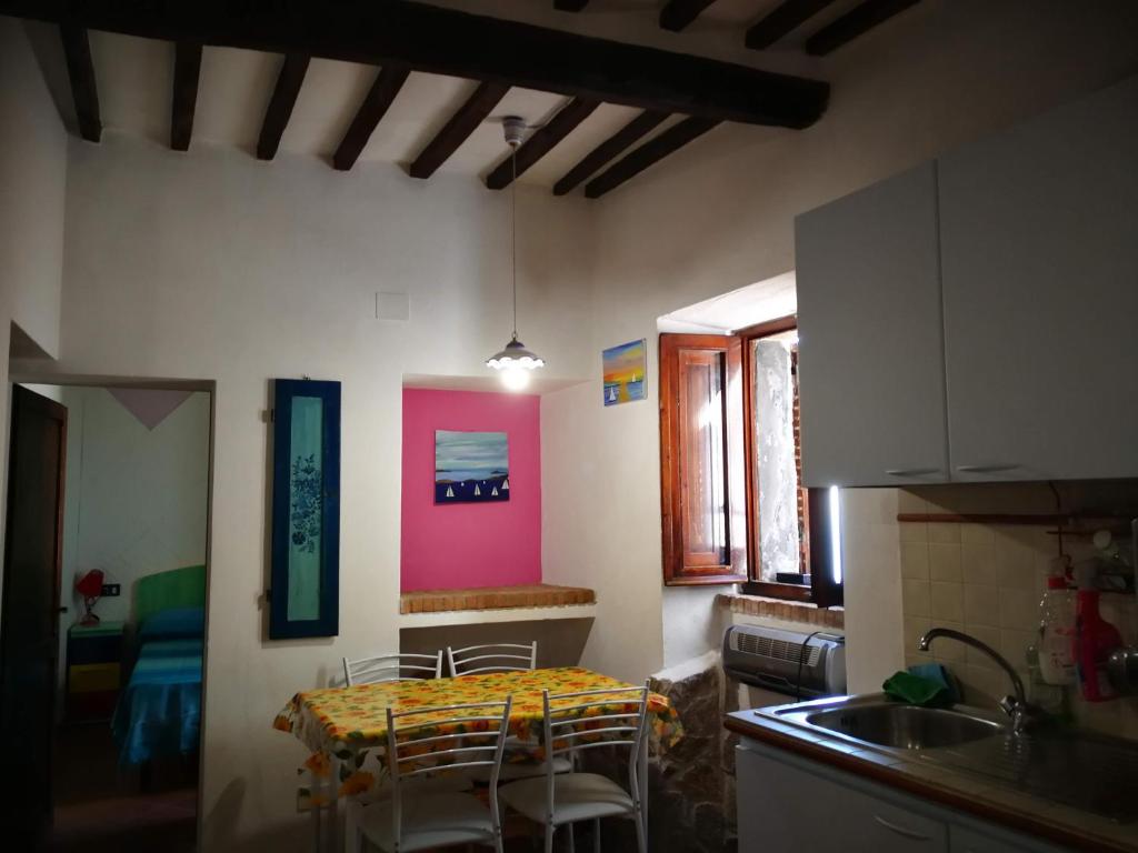 uma cozinha com mesa e cadeiras num quarto em ALLOGGIO S.ANNA em Isola del Giglio