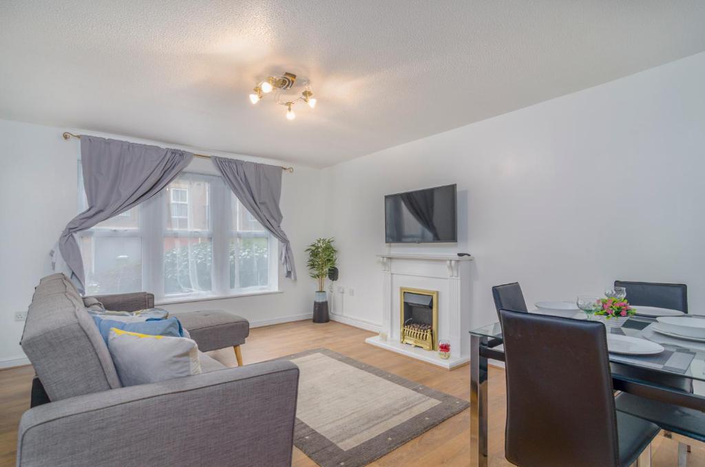 a living room with a table and a dining room at Kentmere Apartment Thamesmead in Thamesmead