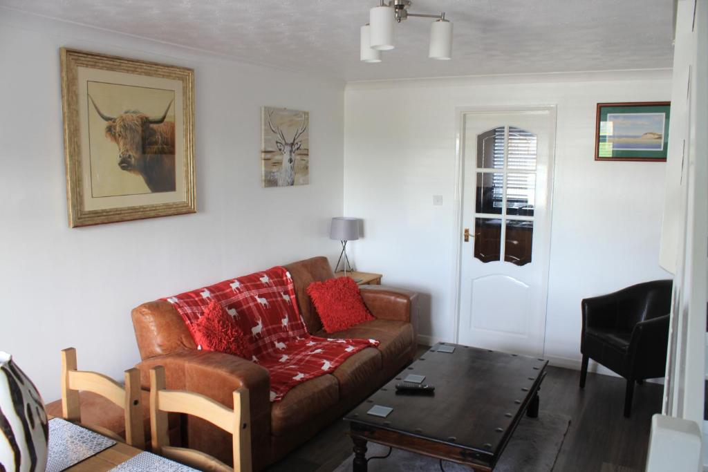 a living room with a couch and a table at 1 Fulmar Road**Next to West Beach and Golf Course in Lossiemouth