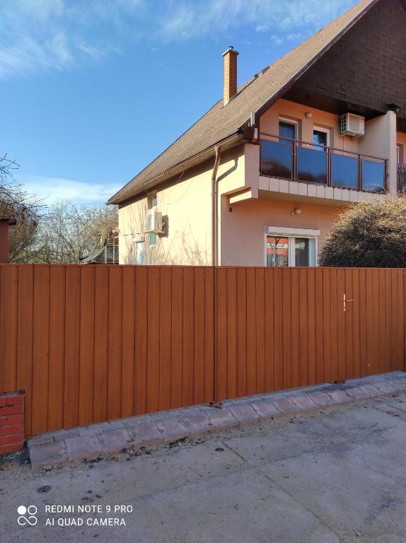 a wooden fence in front of a house at Alina vendégház in Mezőkövesd