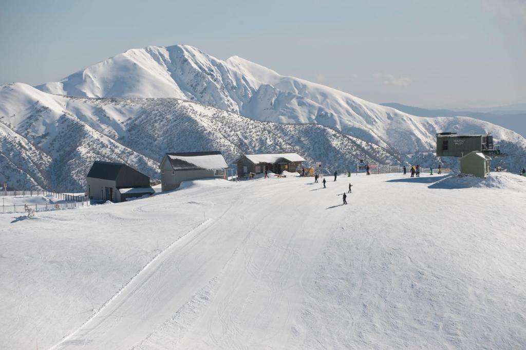 un grupo de personas esquiando por una montaña cubierta de nieve en White Crystal Apartments, en Monte Hotham