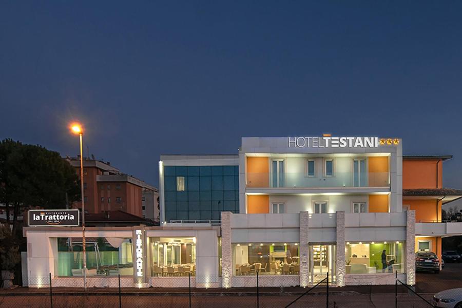 Hotel Testani Frosinone في فروزينوني: مبنى فيه فندق اضاءه بالليل