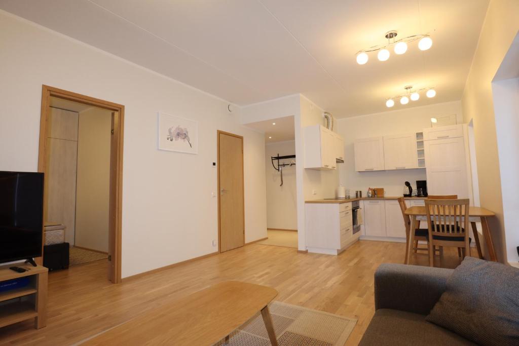 a living room with a couch and a table and a kitchen at Aatrium Kinnisvara Kristalli str apartment Lõunakeskuse lähistel in Tartu