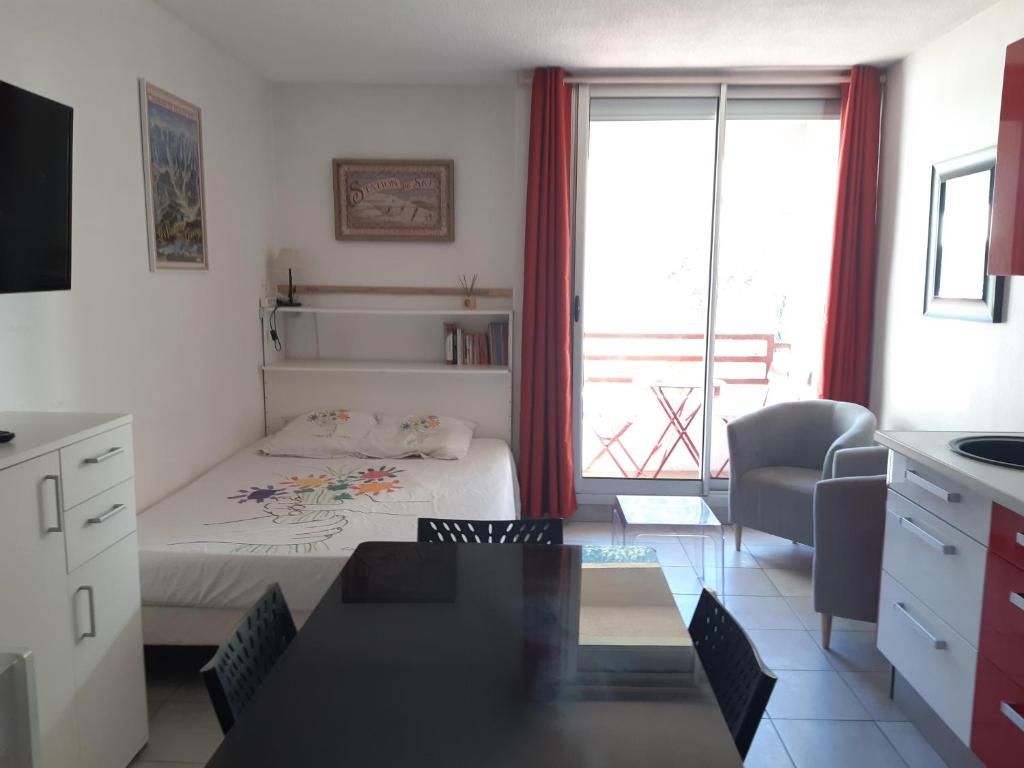 Cet appartement comprend une chambre avec un lit et une cuisine avec une fenêtre. dans l'établissement à la montagne en famille App106, à Cauterets