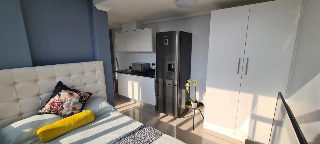 ein Schlafzimmer mit einem Bett und einer Küche darin in der Unterkunft Modern apartments at CZ KUBS in East London