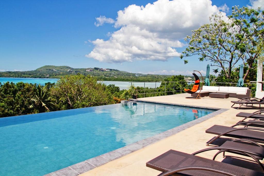 塔比拉蘭的住宿－保和海景套房精品酒店，一个带椅子的游泳池,享有水景