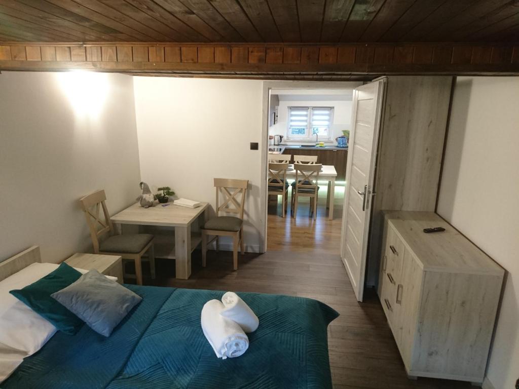 a bedroom with a bed and a dining room at Apartament ELBRUS CZYRNA Szczyrk in Szczyrk