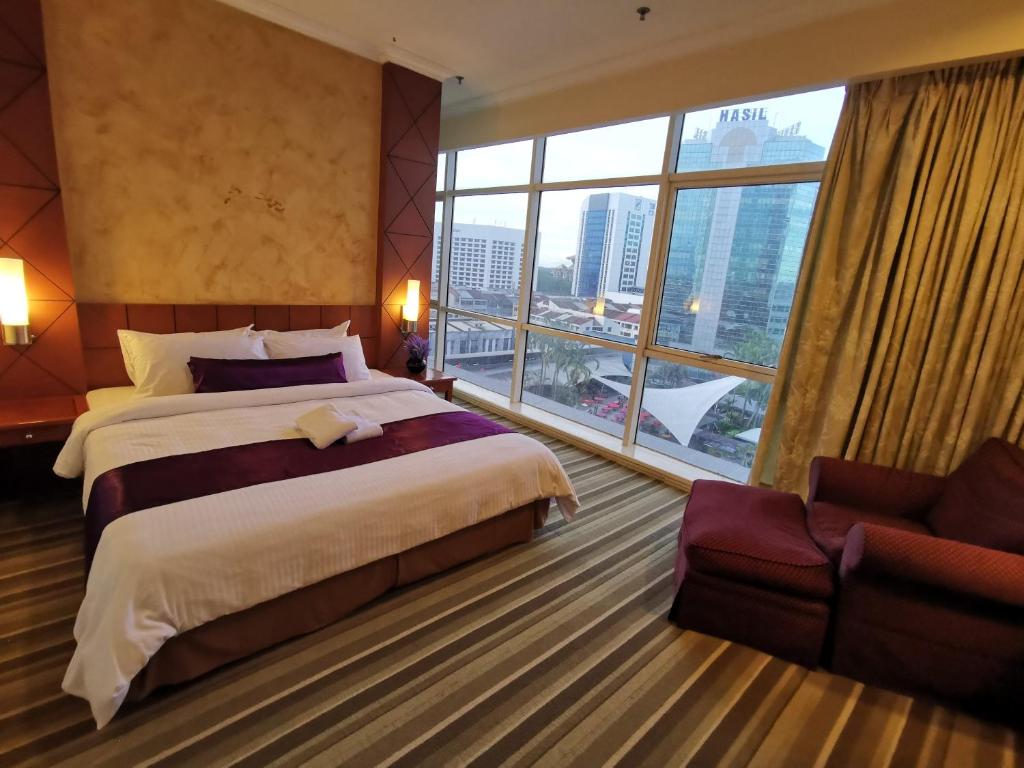 um quarto de hotel com duas camas e uma grande janela em StayInn Gateway Hotel Apartment em Kuching