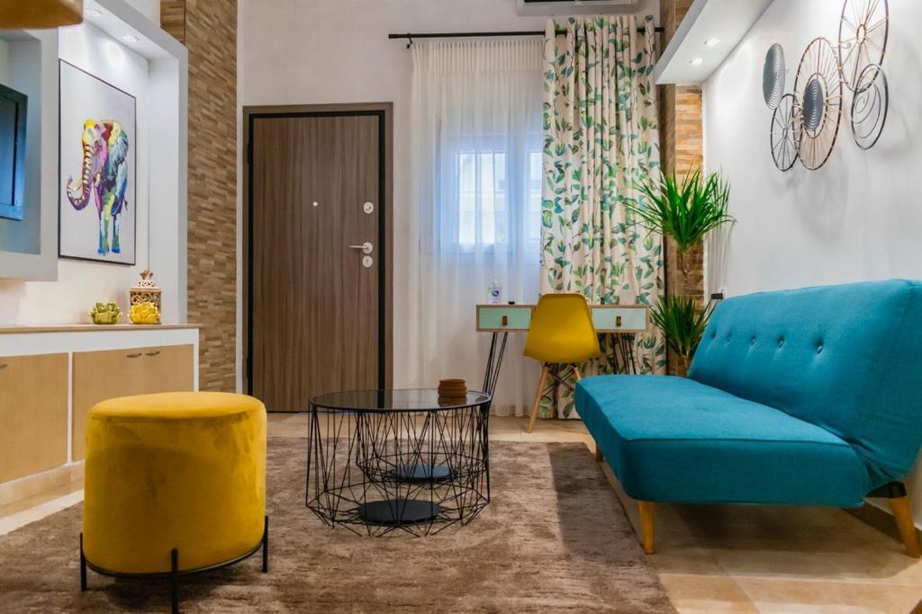sala de estar con sofá azul y silla amarilla en Jolie maison Volos, en Volos