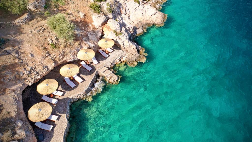 - une vue aérienne sur une plage avec des parasols et l'eau dans l'établissement Agrilia Koromili Retreat, à Paralia Livadostratas