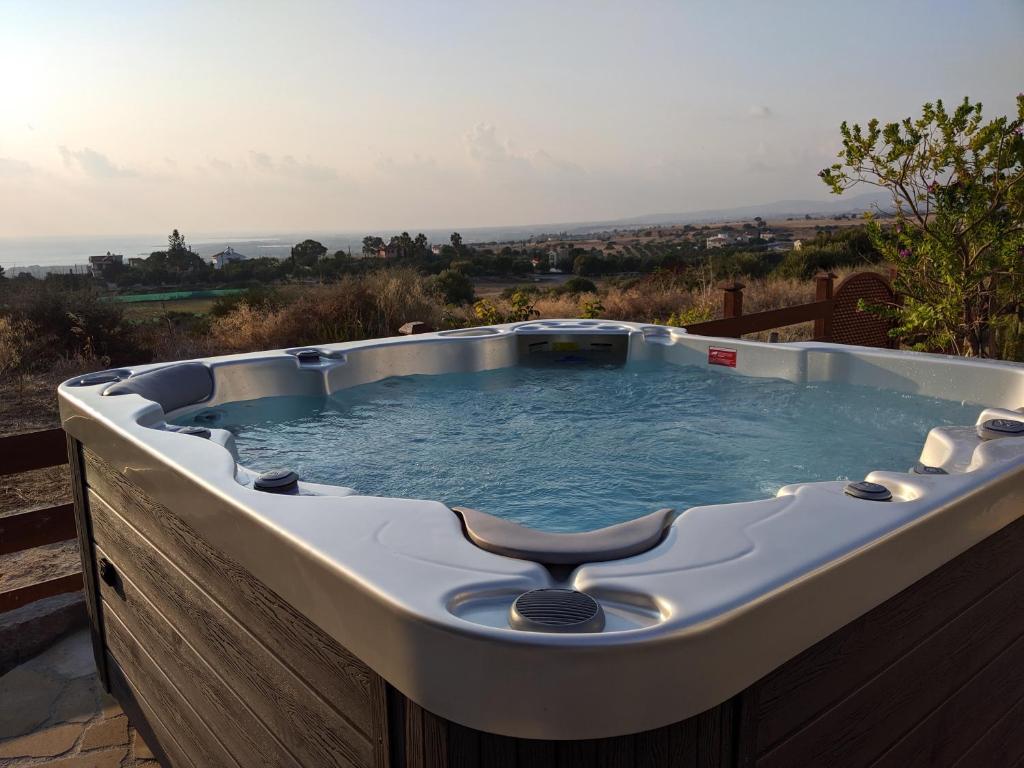 un jacuzzi sentado en la cubierta en Villa Panorama - Stunning views in villa with hot tub, pool, garden, en Kouklia