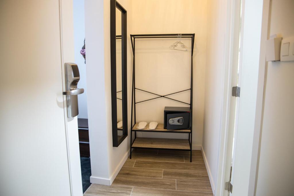 a hallway with a mirror and a clock on a shelf at Hotel Guzy in Lier