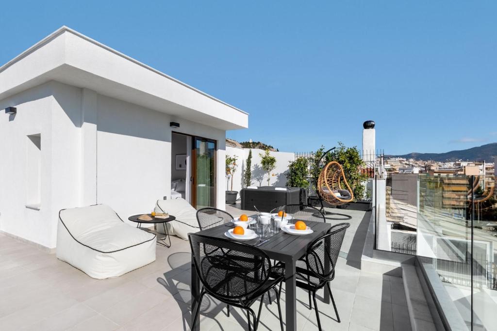 een patio met een tafel en stoelen op een balkon bij Filopappou Hill Suites by Athens Stay in Athene