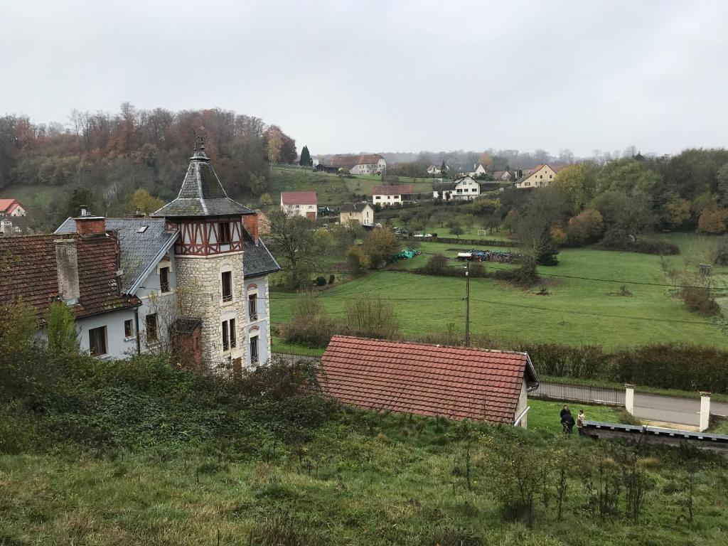 een oud huis op een heuvel in een veld bij L’aile droite du château in Lebétain