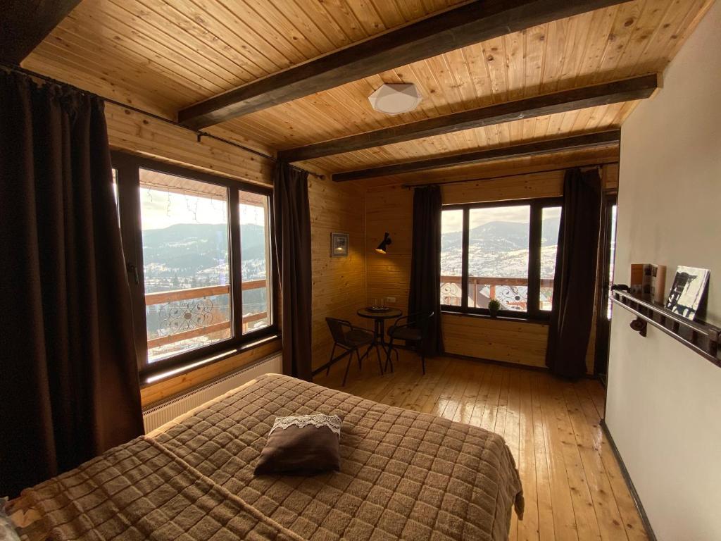 een slaapkamer met een bed en een groot raam bij AGORA Chalet in Slavske