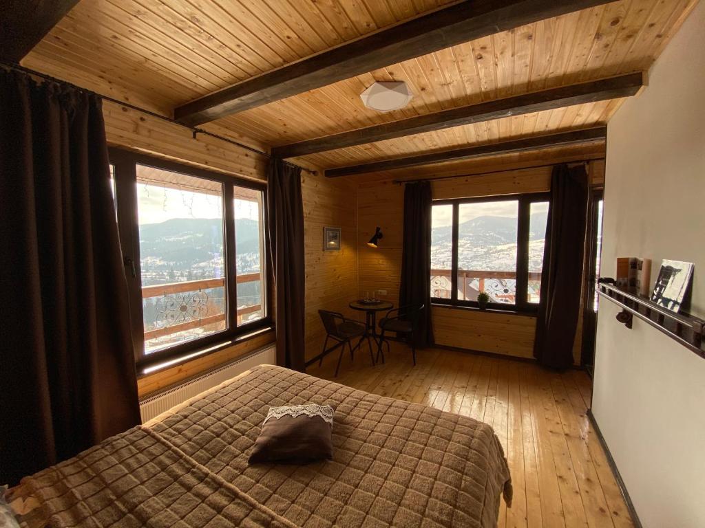 um quarto com uma cama e uma grande janela em AGORA Chalet em Slavske