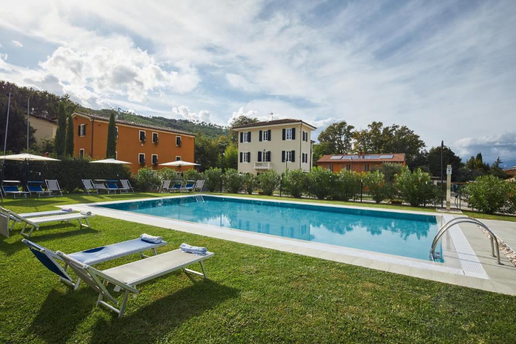 une piscine avec 2 chaises longues et une maison dans l'établissement Casa da Alice, à Lucques