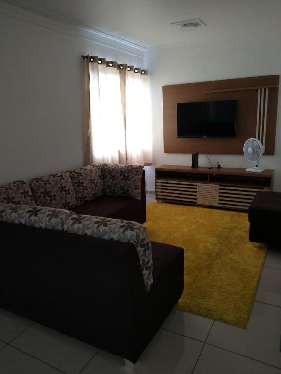 a living room with a couch and a flat screen tv at Apartamento Espaçoso Renato Maia in Guarulhos