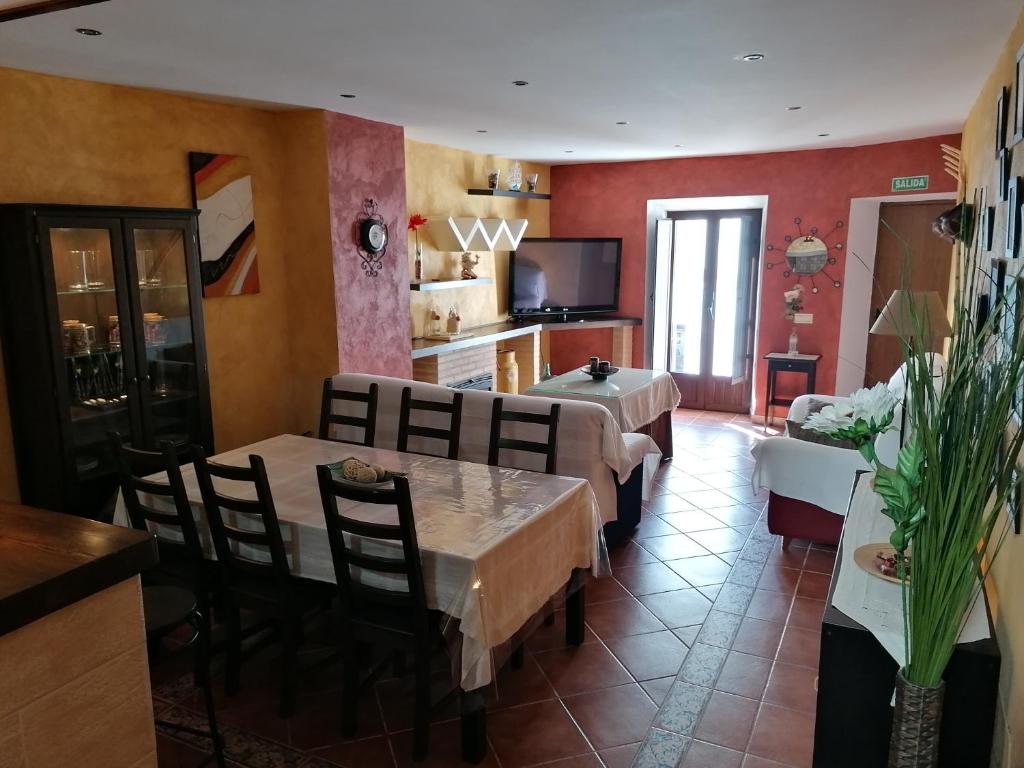 a living room with a table and chairs and a kitchen at La Roca de Setenil in Setenil