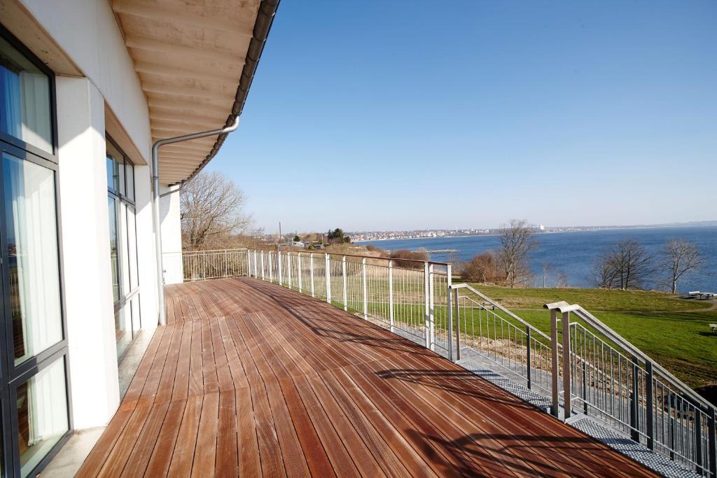 einen Balkon eines Hauses mit Blick auf das Wasser in der Unterkunft Hotel Limfjorden in Thisted