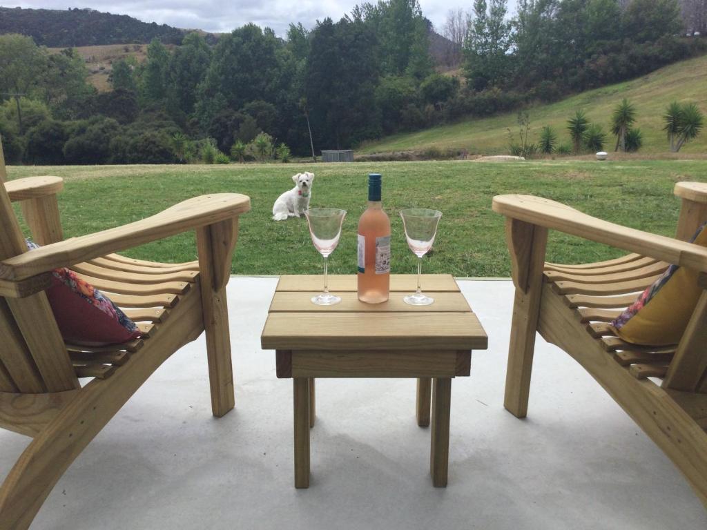 a table with two chairs and a bottle and glasses at Warkworth Barn Retreat in Warkworth