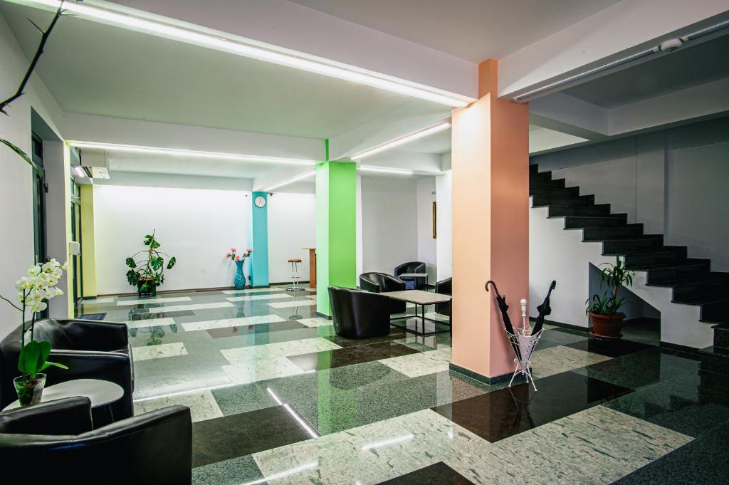 a lobby with chairs and stairs in a building at Colors Residence in Cluj-Napoca