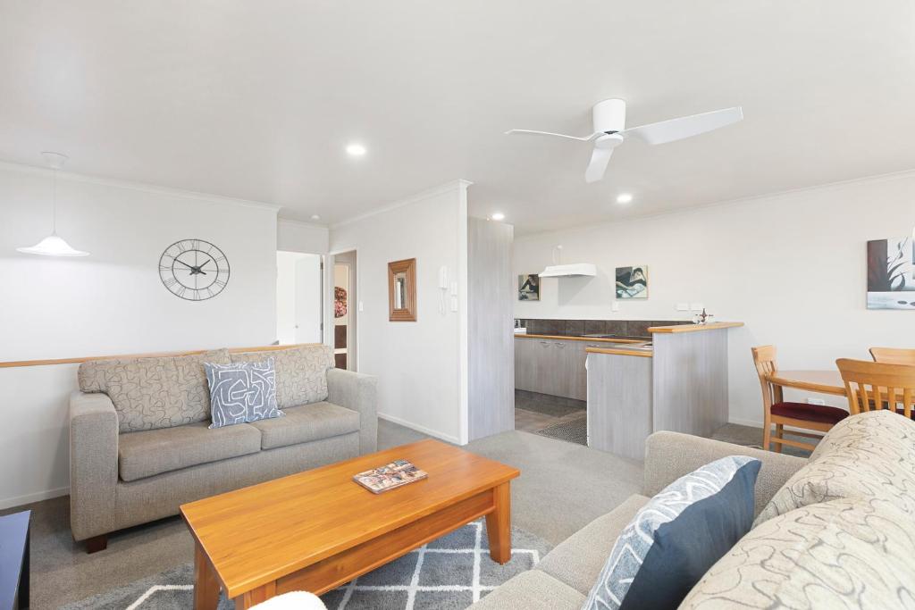 a living room with a couch and a table at Mount Sunset - Mt Maunganui Townhouse in Mount Maunganui