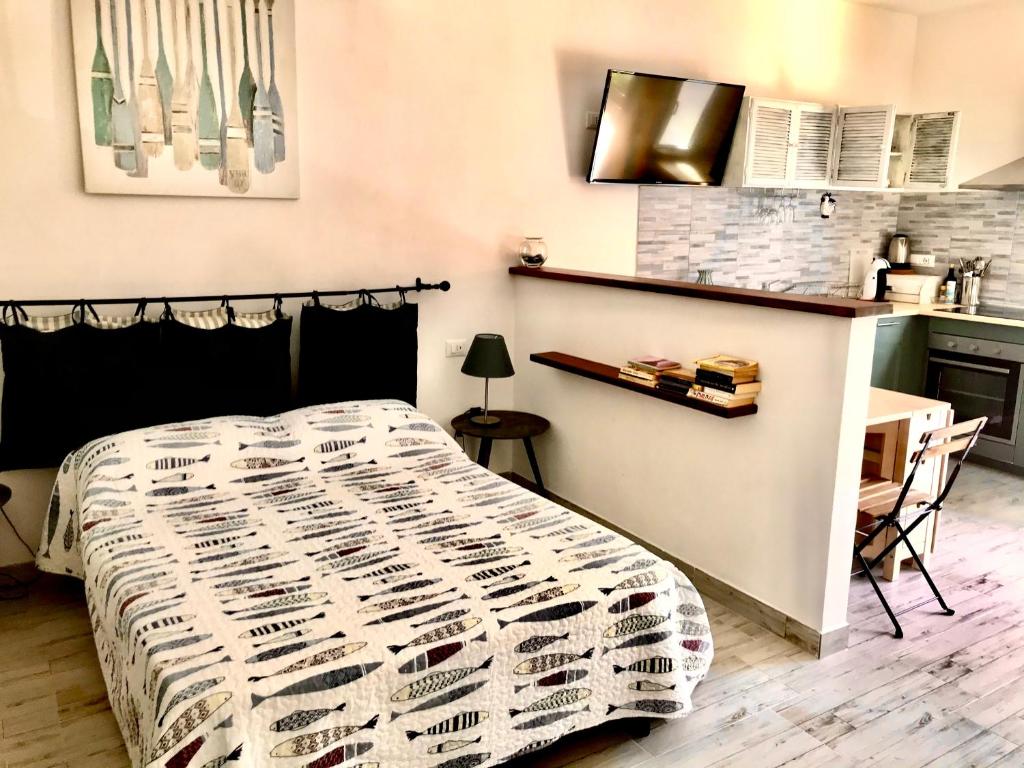 a bedroom with a bed and a desk and a kitchen at Cà Lea,2 Minuti dalla Spiaggia di Monterosso in Monterosso al Mare