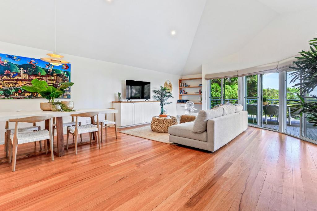 a living room with a table and a dining room at Naturally majestic, Noosa Heads in Noosa Heads