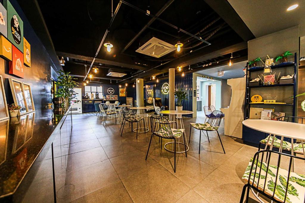 um restaurante com mesas e cadeiras num quarto em Hotel Yeogiuhtte Gyeongpo em Gangneung