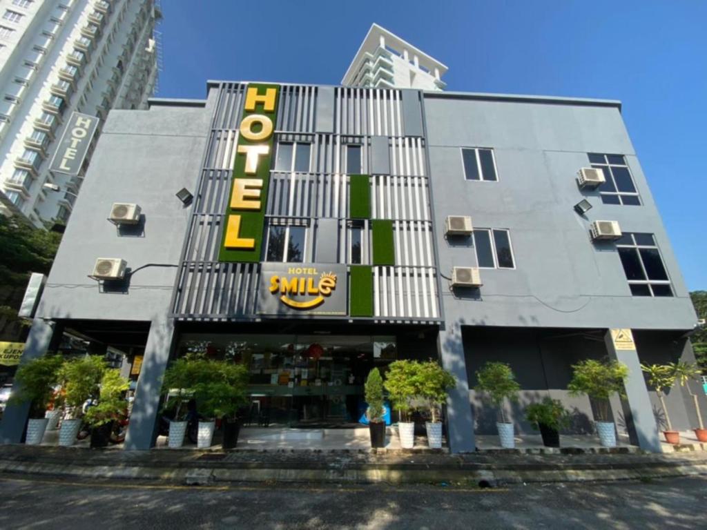 um edifício com um sinal amarelo na frente dele em Smile Hotel Selayang Point em Batu Caves