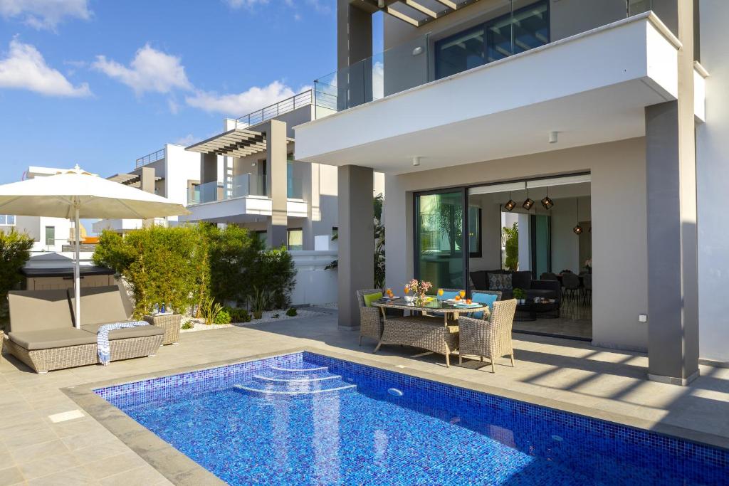 une villa avec une piscine et une maison dans l'établissement Pernera Beach Villa, à Protaras