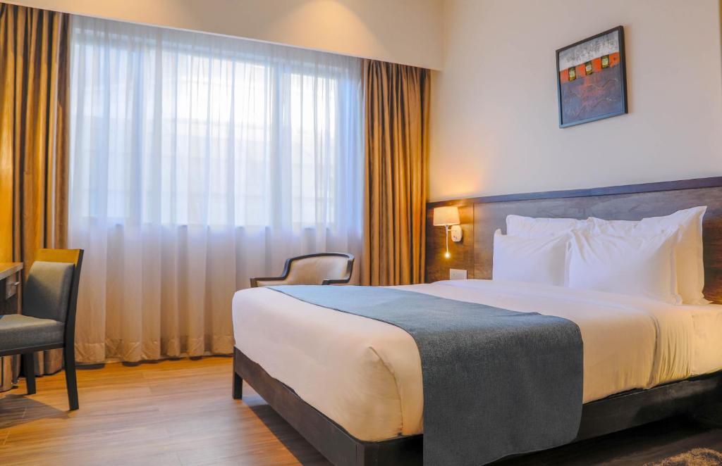 エルドレットにあるEka Hotel Eldoretの大きなベッドと窓が備わるホテルルームです。