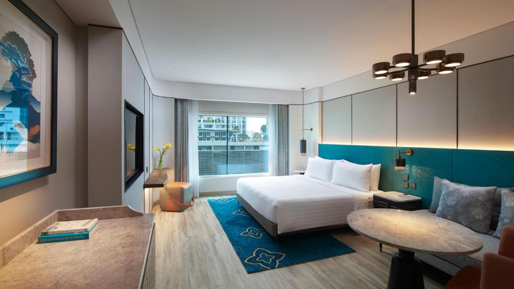 a hotel room with a bed and a table at Amari Bangkok in Bangkok