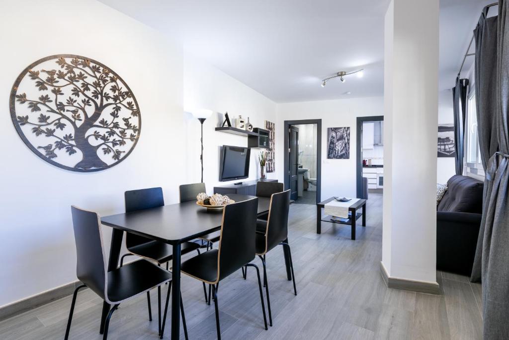 jadalnia i salon ze stołem i krzesłami w obiekcie Maravilloso Ático en Pleno Centro w Maladze