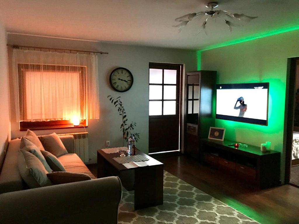 a living room with a couch and a tv with green lights at Gór-SKI Apartament in Szklarska Poręba